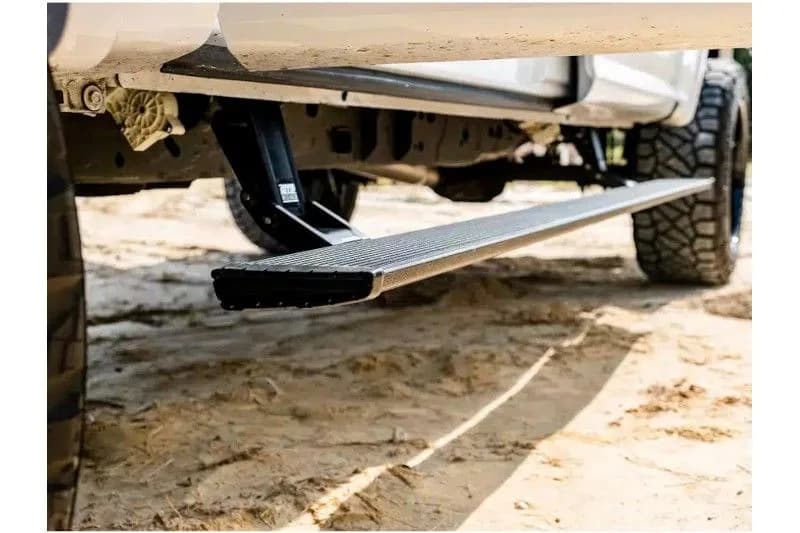 Retractable powered running board deployed beneath a truck cab