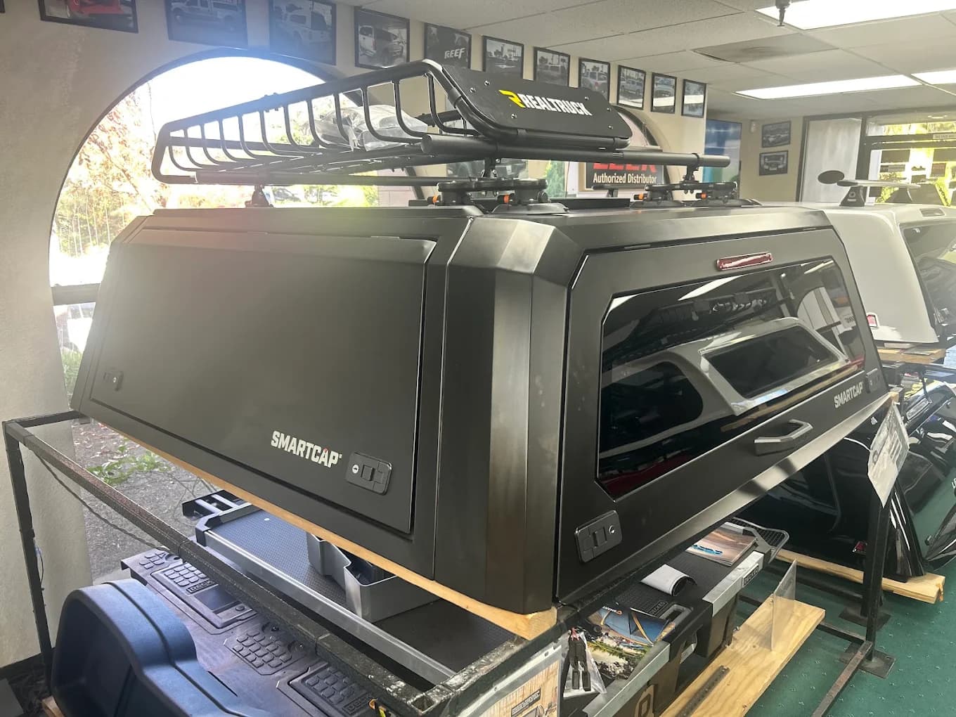 SmartCap canopy on a showroom stand with a RealTruck roof basket mounted above