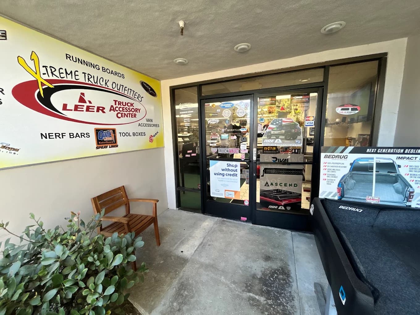 Storefront entrance with painted signage and a BedRug display outside