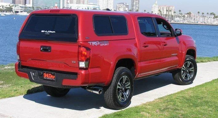 Red Toyota Tacoma fitted with a cab-high SnugTop camper shell