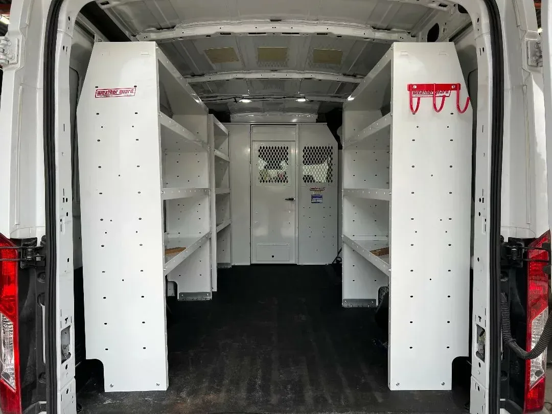 Cargo van interior fitted with white Weather Guard shelving on both walls